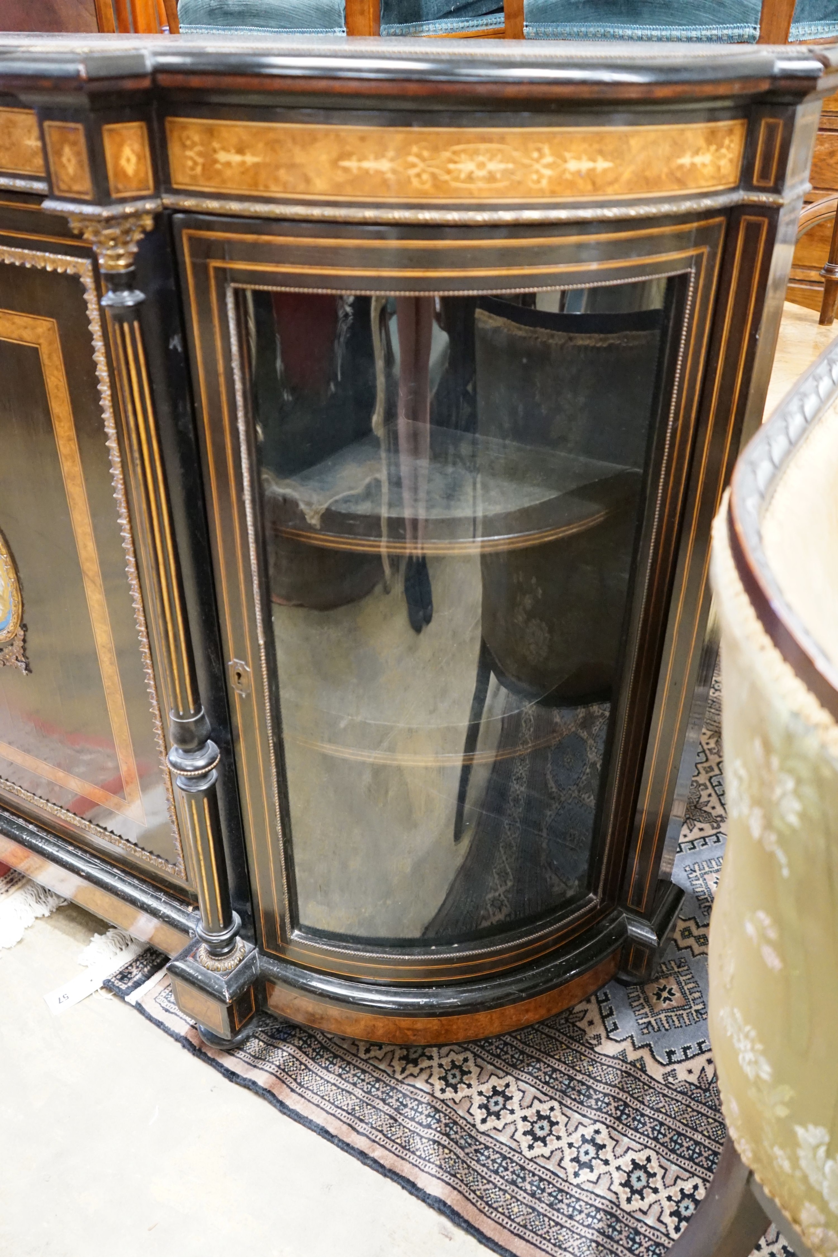 A late Victorian ebonised and amboyna banded credenza, with inset Sevres style porcelain panel, width 154cm, depth 45cm, height 107cm